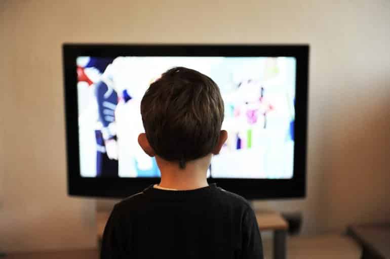 This shows a little boy watching TV