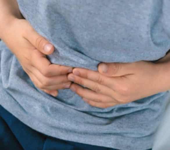 This shows a little boy holding his tummy in pain