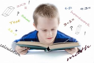 This shows a young boy reading a math textbook
