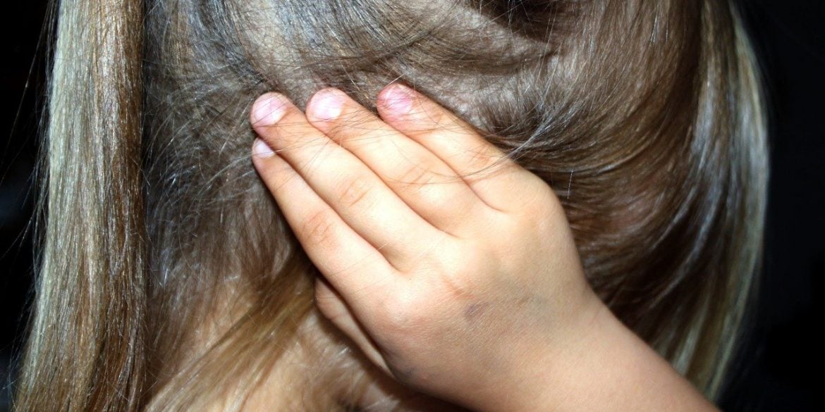 This shows a little girl covering her ears
