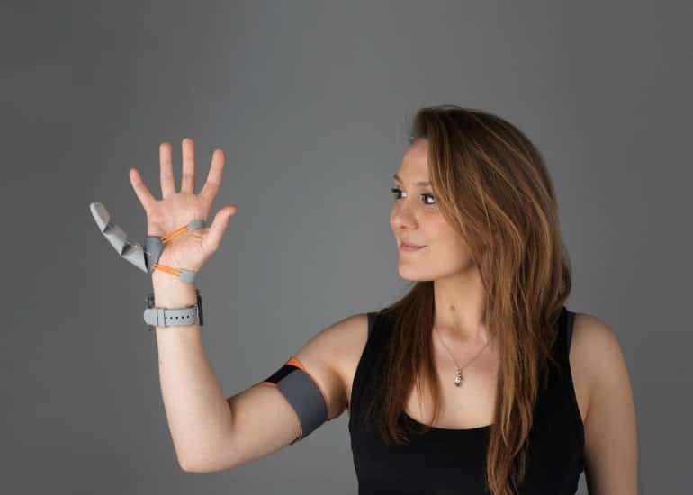 This shows the researcher with the thumb prosthetic on her hand