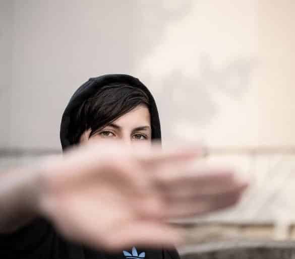 This shows a teenager with their hand up to block view