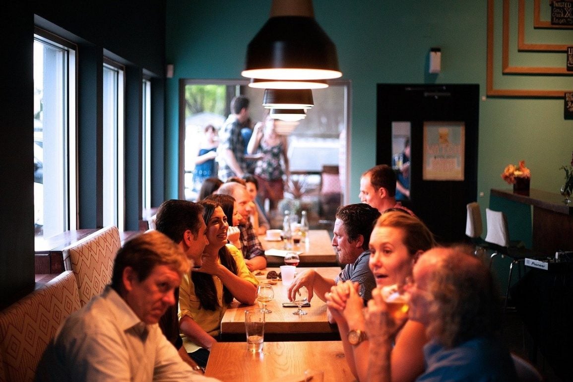 This shows people chatting around a table in a restaurant