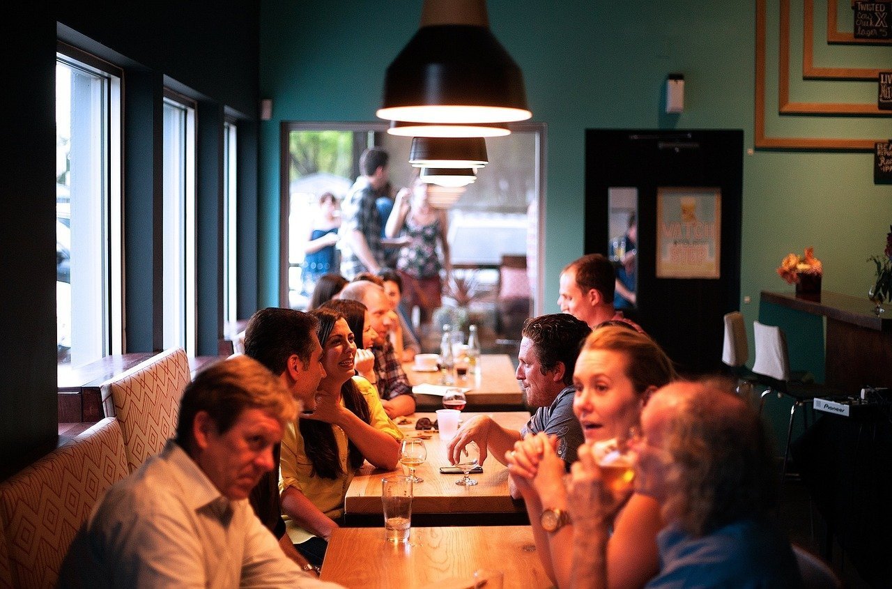 This shows people chatting around a table in a restaurant