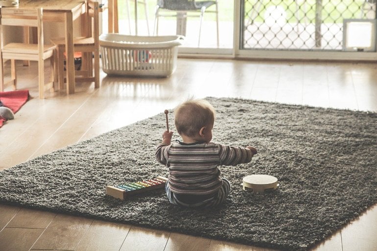 This shows a toddler playing with a toy drum