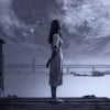 This shows a girl standing on a dock at night looking at an oversized moon
