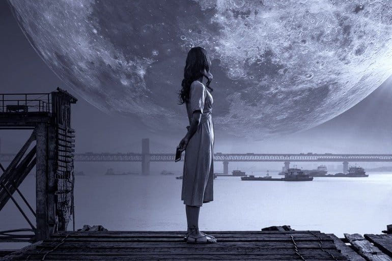 This shows a girl standing on a dock at night looking at an oversized moon