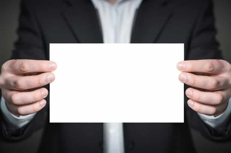 This shows a man holding a blank piece of paper