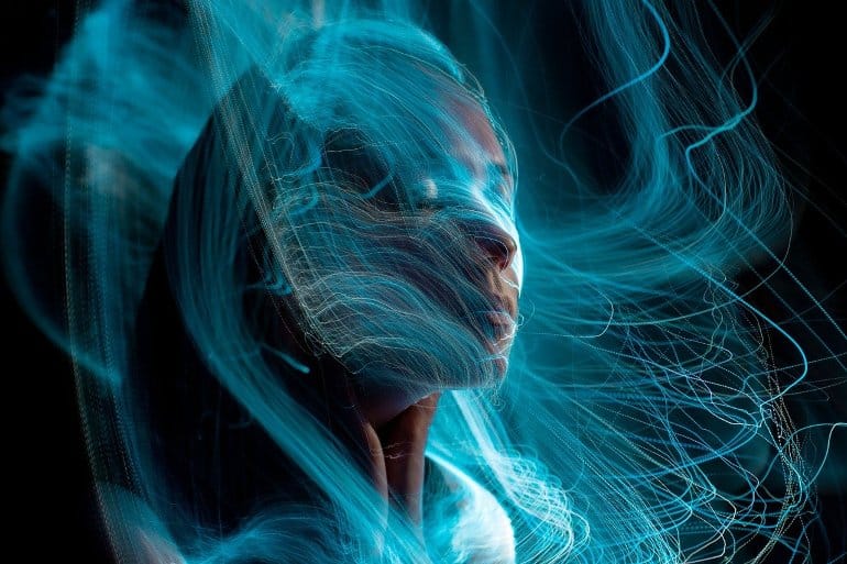 This shows a woman wrapped in blue, fuzzy lines