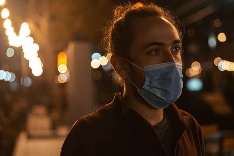 This shows a nervous looking young man in a facemask