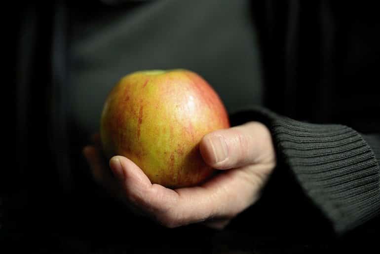 Isso mostra uma mulher segurando uma maçã