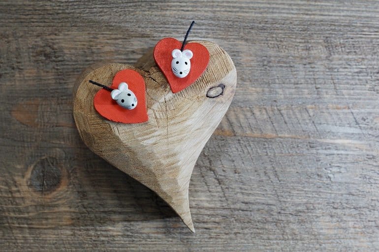 This shows two mouse toys on a wooden heart