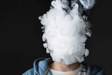 This shows a man who's head is completely surrounded with vape smoke
