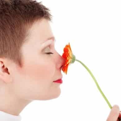 This shows a woman smelling a flower