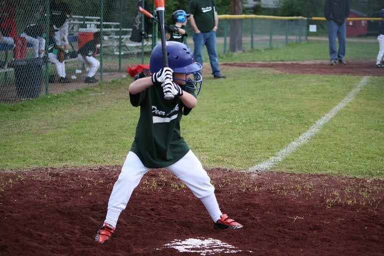 Isso mostra um garotinho jogando beisebol