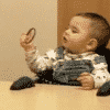 This shows a baby examining a circular object