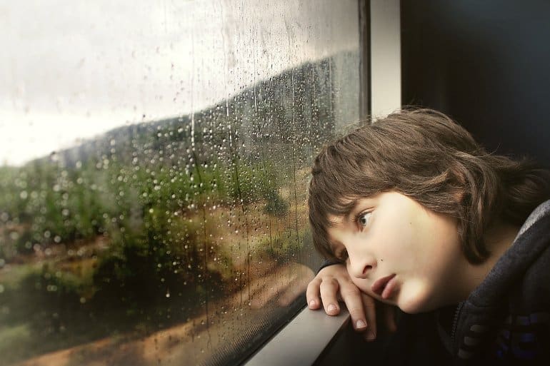 This shows a child looking out of a window