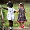 This shows two little girls walking in a park