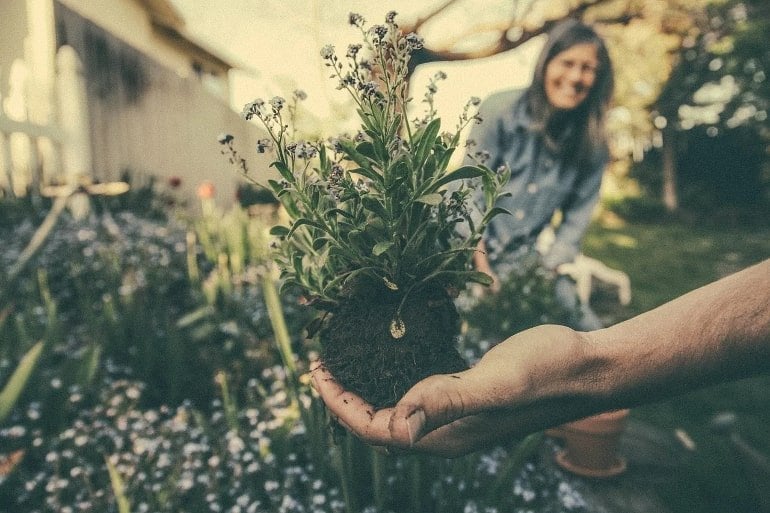 Isso mostra uma senhora feliz fazendo jardinagem