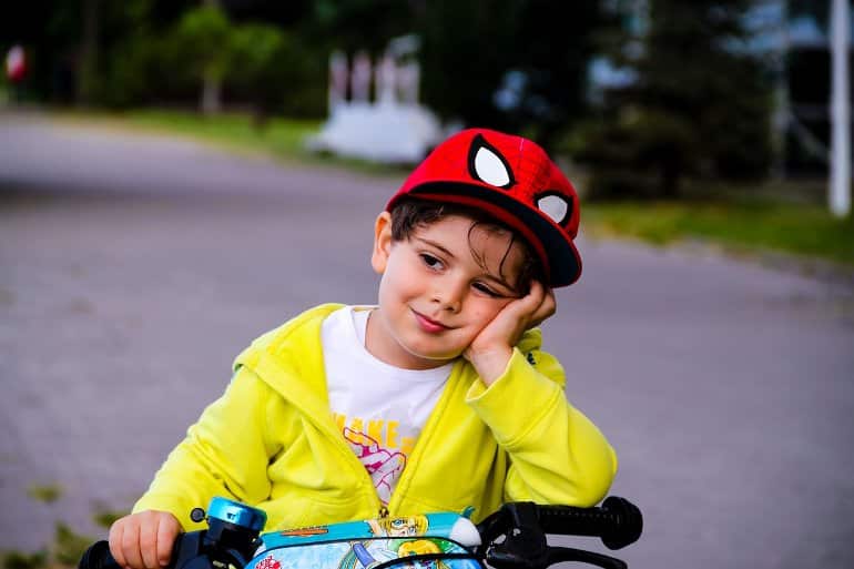 This shows a little boy looking sleepy. He's wearing an awesome Spiderman hat