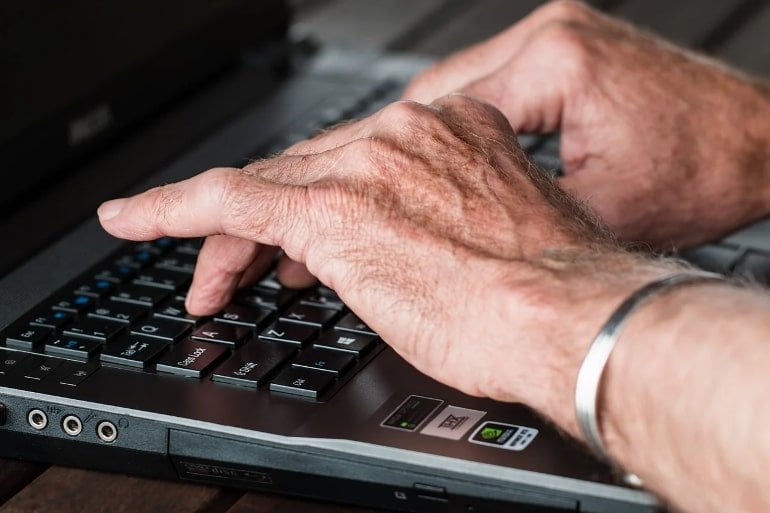 This shows a man with arthritic hands typing