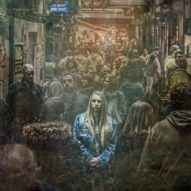 This shows a woman standing alone in a crowd