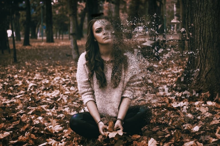 Isso mostra uma mulher desaparecendo sentada em uma floresta