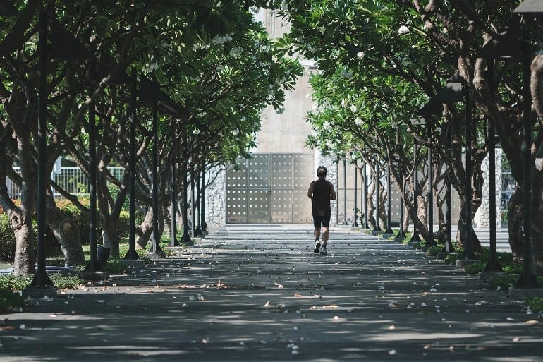 This shows a man jogging in a park