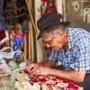 This shows an older man working on creating a rug