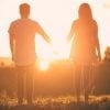 This shows a couple holding hands in the sunset