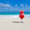 Cela montre un cocktail dans le sable sur une plage.