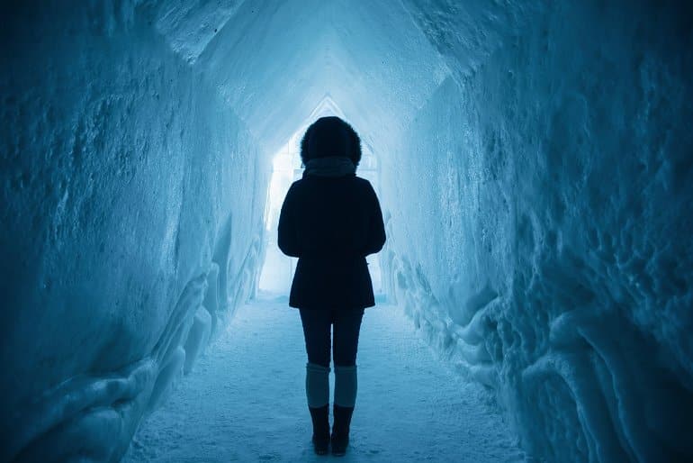 This shows a woman walking through an icy tunnel