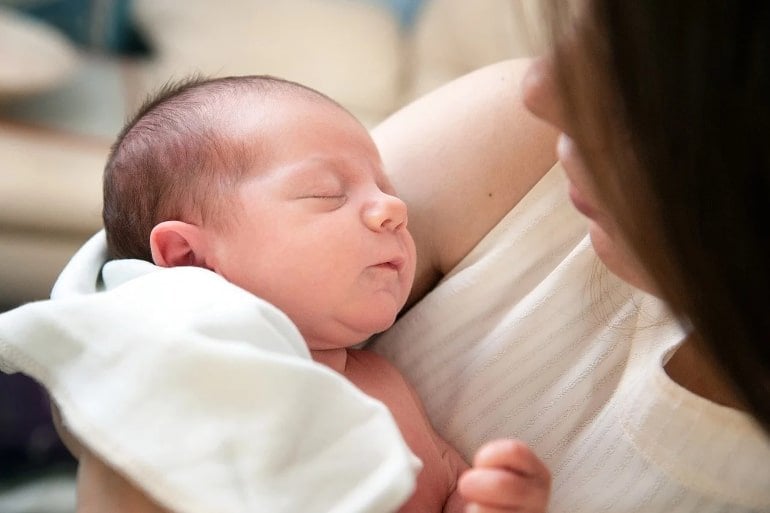 This shows a mom holding her newborn