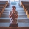 This shows a man praying in church
