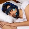 This shows a man sleeping with the SleepLoop system on his head