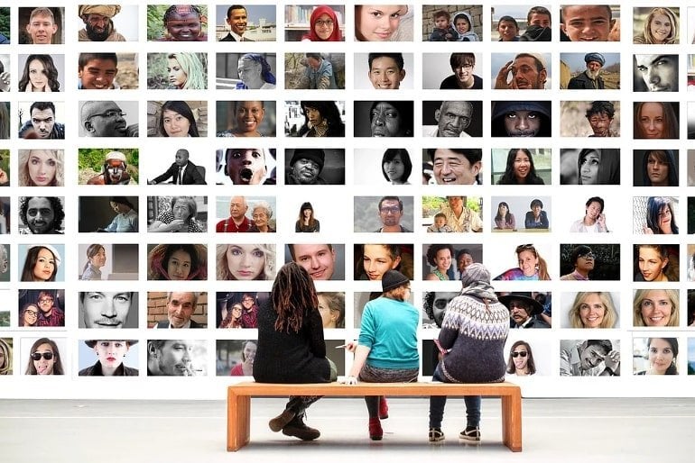 This shows three people viewing other people's faces in an art gallery