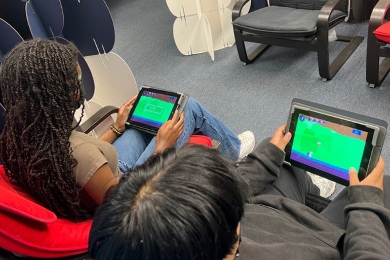 This shows two people playing brain games on tablets