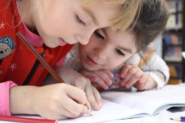 This shows two little girls doing school work