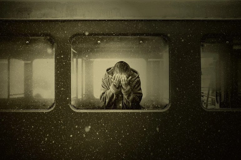 This shows an older woman crying on a train