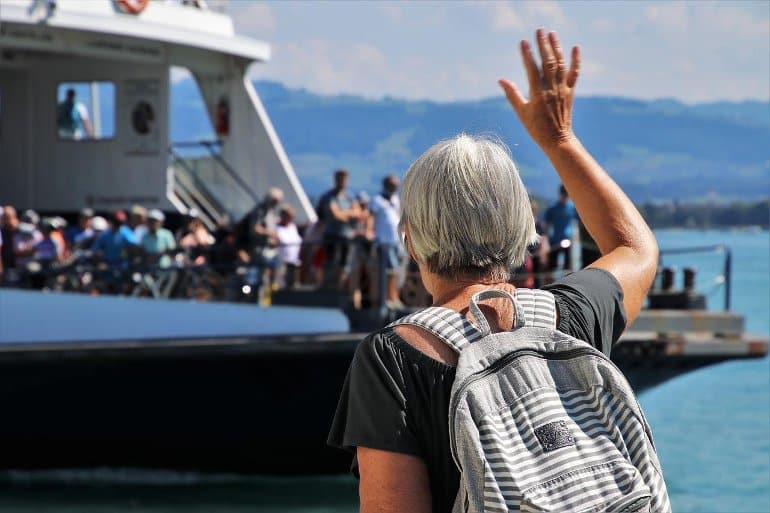 This shows an elderly woman approaching a crowded yacht