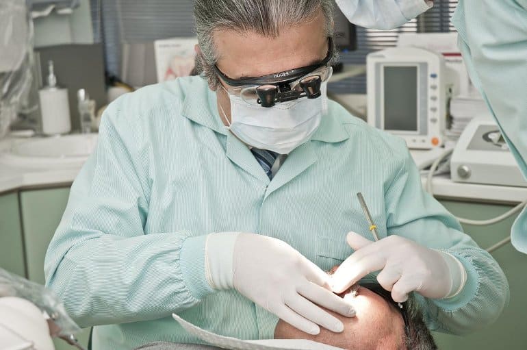 This shows a dentist examining a person's teeth