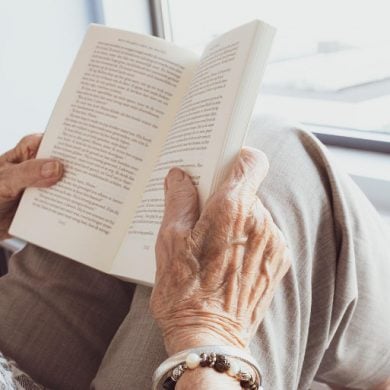 This shows an older lady reading a book