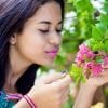 This shows a woman smelling flowers