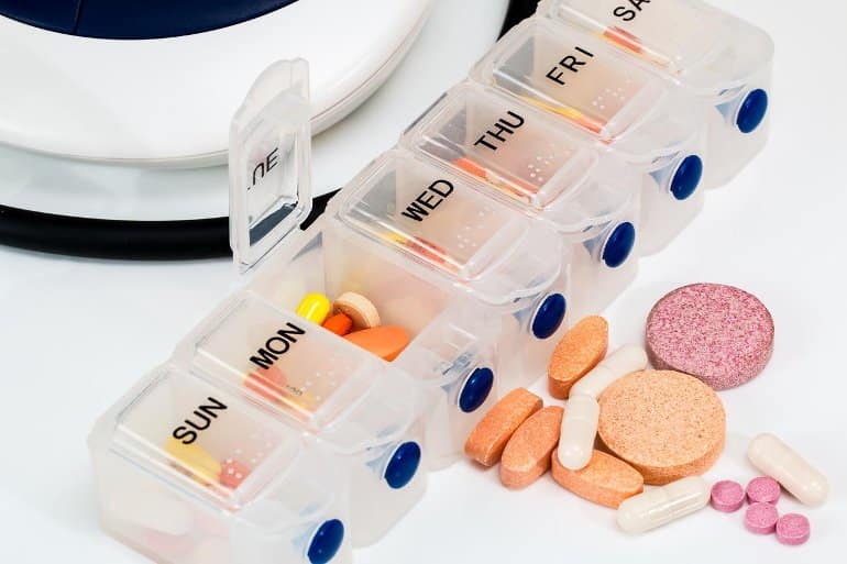 This shows vitamin pills in a daily pill holder