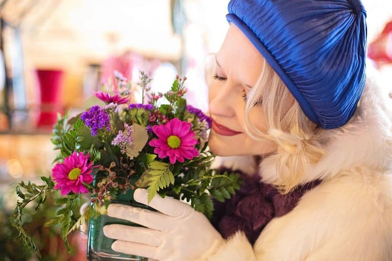 This shows a woman smelling flowers