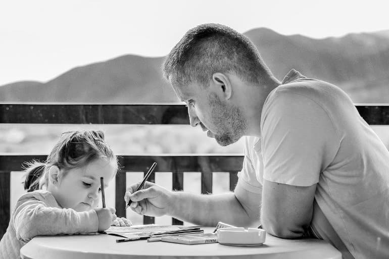 This shows a dad helping his daughter with homework