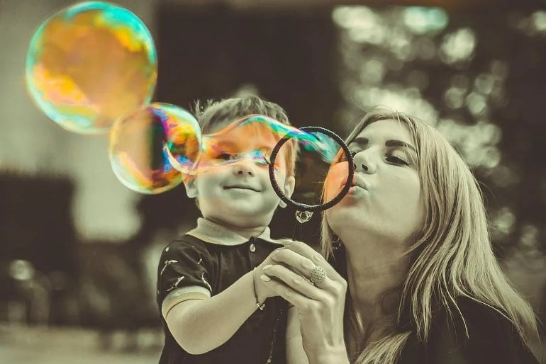 This shows a mom and her son blowing bubbles