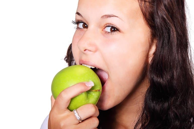 This shows a woman eating an apple
