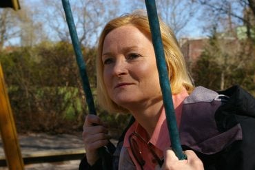 This shows a woman sitting on a swing