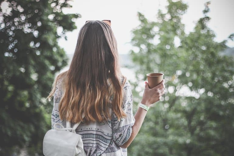 This shows a woman drinking her morning coffee